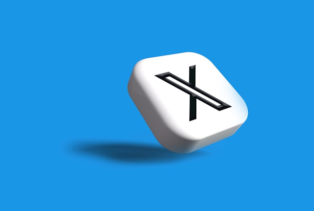Uma imagem 3D de um cubo branco inclinado com o logotipo X em um fundo azul.