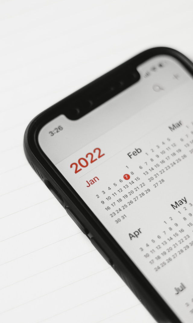 Una persona que marca en un calendario de su iPhone cuándo debe comprobar si su cuenta tiene un shadowban de Twitter.