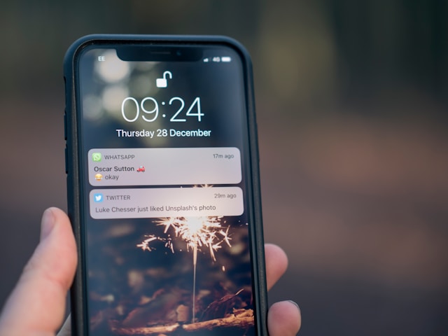 Una persona con un teléfono en la mano y una notificación push de Twitter en la pantalla.