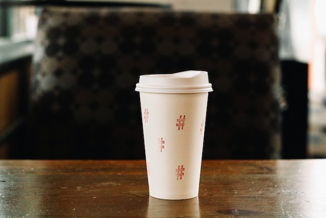 Gambar cangkir kopi plastik dengan simbol tagar di sekujur tubuhnya.