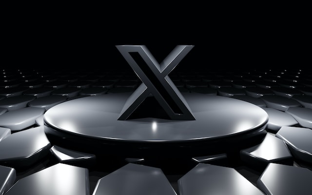 Un'immagine di un logo X nero in piedi su una piattaforma circolare nera.