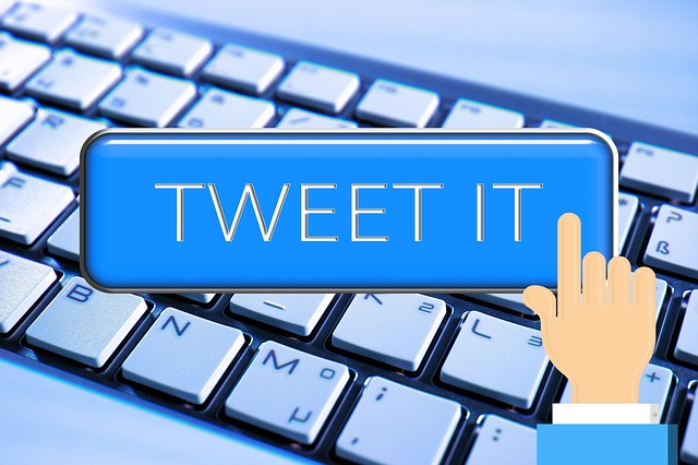 Illustrazione di una mano che fa clic su un pulsante con la scritta "tweet it" su una tastiera di computer sullo sfondo.