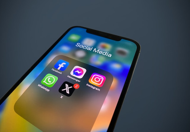 Un'immagine di una vista ravvicinata dell'icona dell'app X e di altre icone di social media in una cartella su uno smartphone.