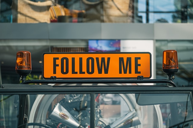 Follow Me "と書かれた黄色い道路標識の写真。