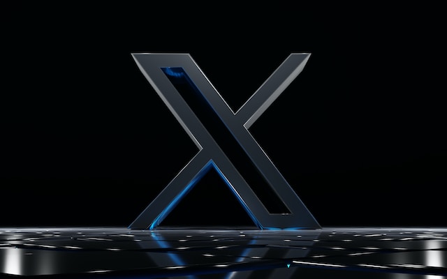 Een 3D-afbeelding van het nieuwe X-logo van Twitter, afgebeeld in grijs op een donkere achtergrond.
