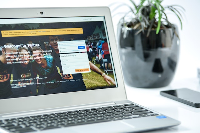 Een afbeelding van de aanmeldingspagina van X of Twitter weergegeven op een grijze laptop.