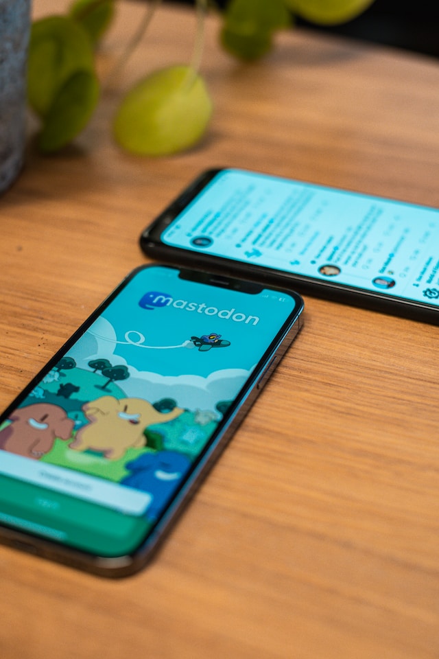 Grande plano de um iPhone com a aplicação Mastodon e de um dispositivo Android com a aplicação oficial do Twitter aberta.
