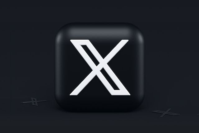 Uma imagem do novo logótipo da X desenhada a branco num cubo preto colocado sobre um fundo preto.