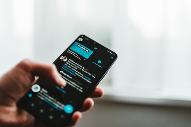 Uma imagem de uma pessoa a percorrer os seus feeds X num smartphone.