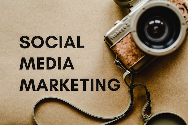 Uma fotografia de uma máquina fotográfica antiga num papel castanho com a inscrição "SOCIAL MEDIA MARKETING".