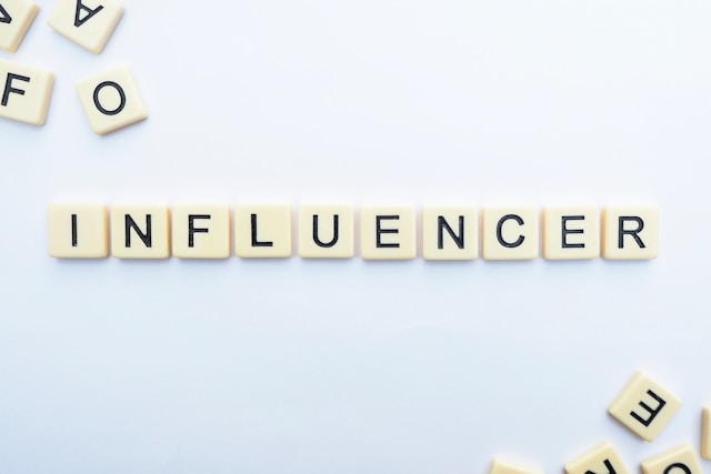 Beyaz zemin üzerine Scrabble taşları "INFLUENCER" yazılacak şekilde dizilmiştir.